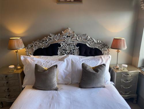 a bedroom with a bed with white sheets and pillows at The White House Hotel in Newquay
