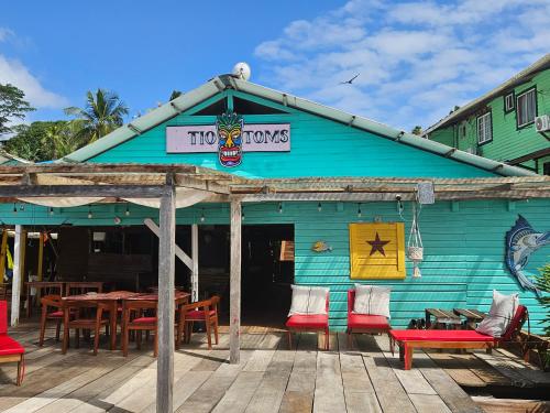 a blue building with a table and chairs on a deck at Tio Toms Guesthouse in Bastimentos