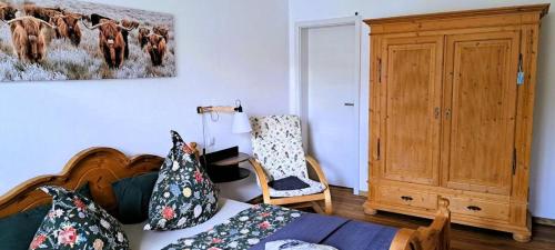 a bedroom with a bed and a painting of cows at Ferien im Kühbergstadl in Bischofsmais