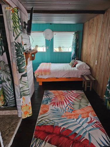a small bedroom with a bed and a rug at Tio Toms Guesthouse in Bastimentos
