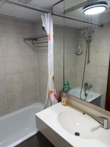 a bathroom with a sink and a tub and a mirror at Sea view apartments in Caesarea