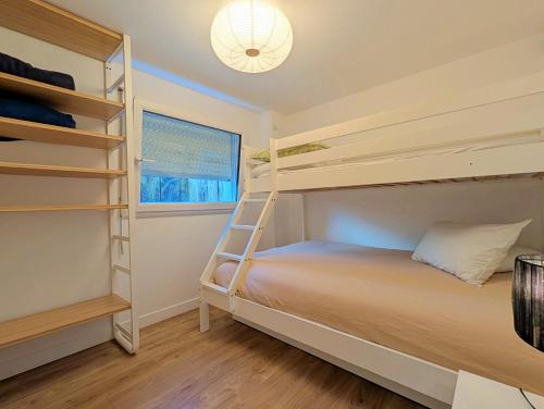 a bedroom with two bunk beds and a window at Aux cigognes de Blotzheim in Blotzheim