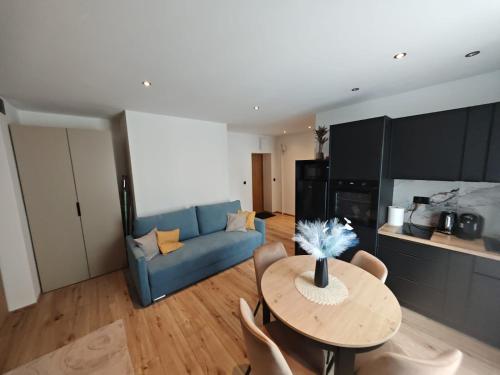 a living room with a table and a blue couch at Apartament WLK HOUSE in Gdynia