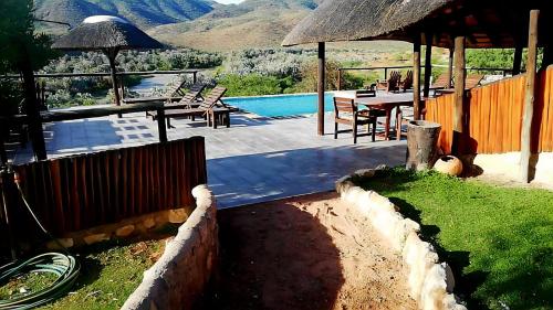 a house with a pool and a table and chairs at Kapika Waterfall Lodge in Epupa