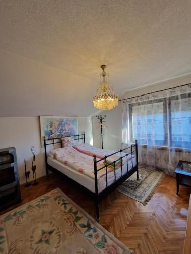 a bedroom with a bed and a chandelier at Stara Ruža in Gračanica