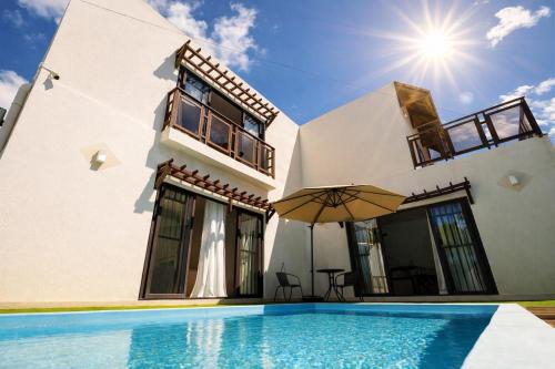 a villa with a swimming pool in front of a house at Hope Villa in Calodyne