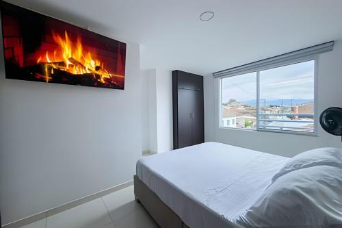 a bedroom with a bed with a fire in the wall at amplio y lujoso apartasuite en el centro in Cartago