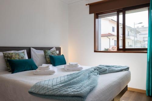 a bedroom with a large bed with a window at Trajadinha do Lima Apart in Ponte de Lima