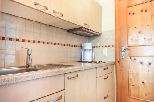 a small kitchen with a sink and a microwave at Hotel garni Oberdorfer Stuben in Obermaiselstein