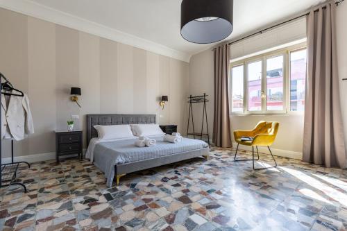 a bedroom with a bed and a chair and windows at Lorixedda Rooms in Quartu SantʼElena
