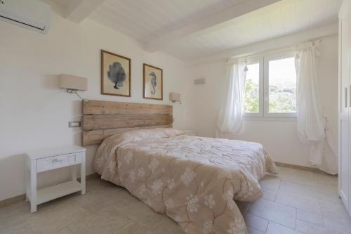a white bedroom with a bed and a window at Villa Belvedere - Helloelba in Santa Caterina