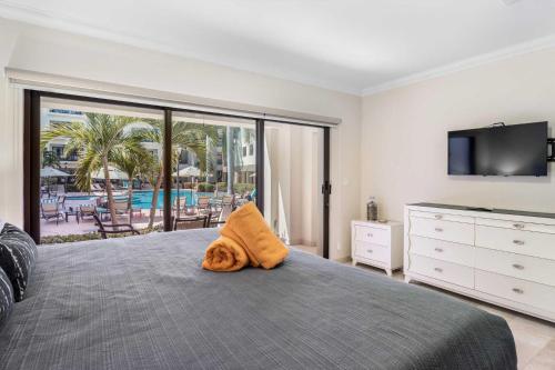 a bedroom with a bed with an orange towel on it at PC103 - easy Pool Access - Perfect for family in Palm-Eagle Beach