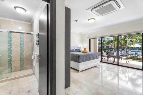 a bedroom with a bed and a sliding glass door at PC103 - easy Pool Access - Perfect for family in Palm-Eagle Beach