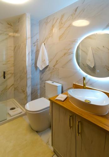 a bathroom with a sink and a toilet and a mirror at Villa Maria Caetana in Frazão