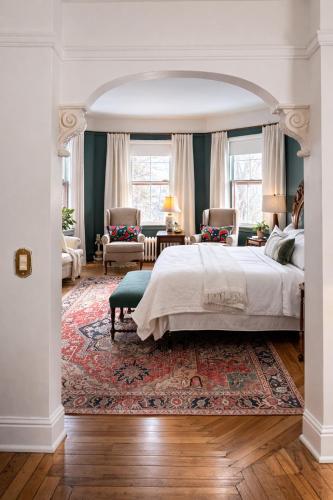 a bedroom with a large bed and a living room at Elmwood Heritage Inn in Charlottetown