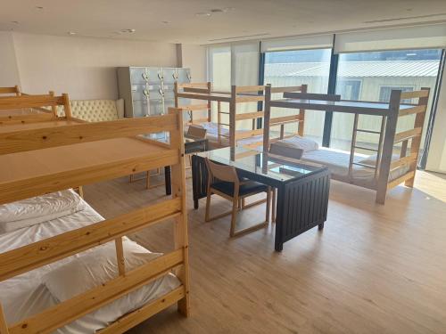 a dorm room with several bunk beds and a table at Comin' Place HSR Hotel in Wuri