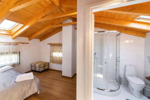 a bedroom with a bed and a shower and a toilet at Villa Loulou by Villa Plus in Nikiana