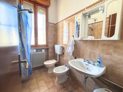 a bathroom with a sink and a toilet and a mirror at CV019 - Cervia, bilocale con balcone e posto auto in Milano Marittima