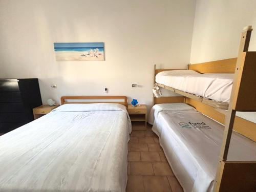 a room with two bunk beds and a room with at CV019 - Cervia, bilocale con balcone e posto auto in Milano Marittima
