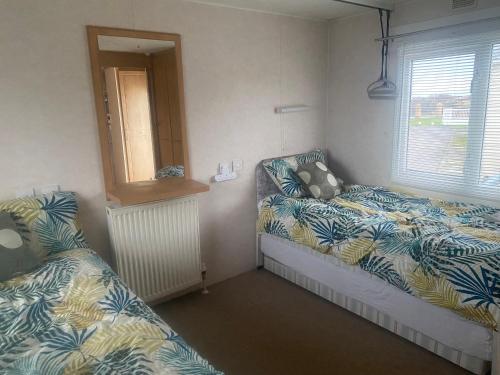 a bedroom with two beds and a window at Woodlands Dene - Crimdon Dene Holiday Park - Accessible in Hartlepool