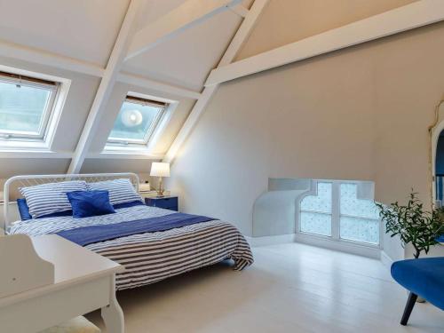 a bedroom with a bed and a table and windows at 2 Bed in Penzance oc-85610 in St. Just