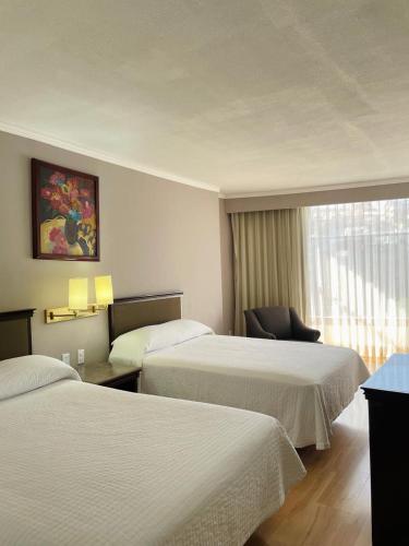 a hotel room with two beds and a window at Arroyo Express in Zacatecas