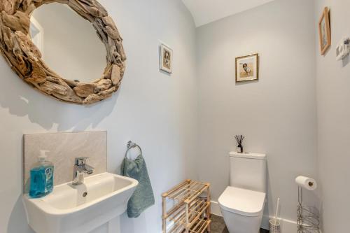 a bathroom with a sink and a toilet and a mirror at 3 Bed in Croyde oc-hector in Croyde