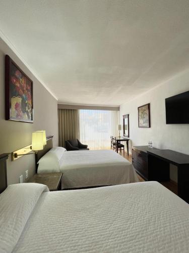 a hotel room with two beds and a flat screen tv at Arroyo Express in Zacatecas