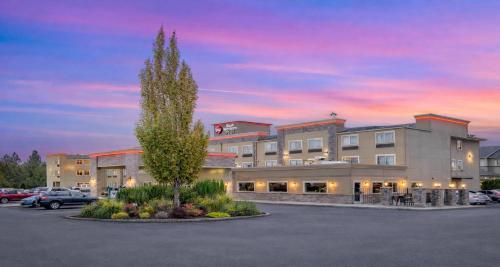 a building with a tree in a parking lot at Best Western PLUS Peppertree Airport Inn in Spokane