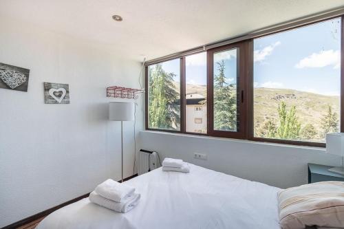 a bedroom with a bed and a large window at Sueño blanco in Sierra Nevada