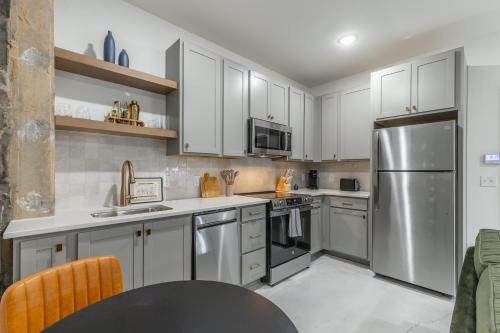 a kitchen with white cabinets and a stainless steel refrigerator at Park Hotel 1BR Suite 310 in Chattanooga
