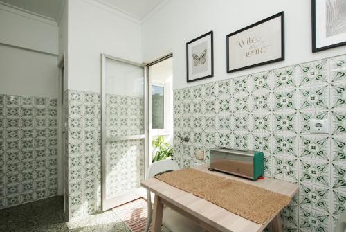 a room with a table and a wall with tiles at Low Cost University Privado in Lisbon