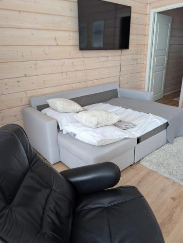 a bed in a room with a television and a chair at Lake Norva Lodge in Saarenkylä
