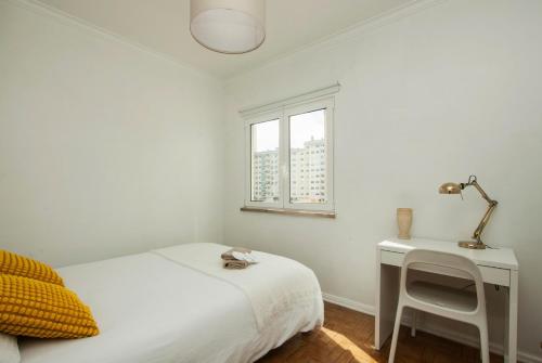 a white bedroom with a bed and a desk at Low Cost University Privado in Lisbon