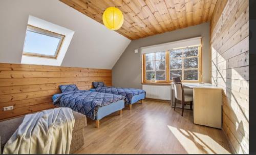 a bedroom with two beds and a desk and a table at Kasekuma House with all comforts well located in Otepää