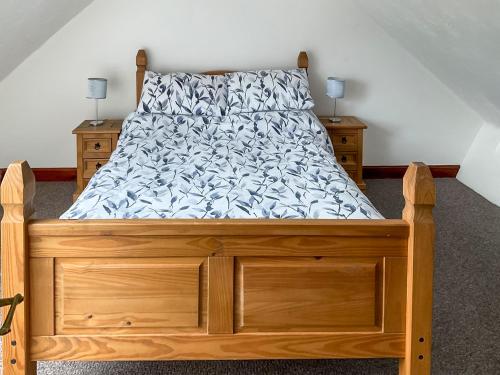 a bedroom with a bed with a wooden bed frame at Mistletoe Cottage - Uk50581 in Burnham on Sea