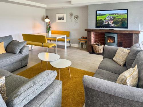 a living room with two couches and a fireplace at Keppel Gate in Heriot