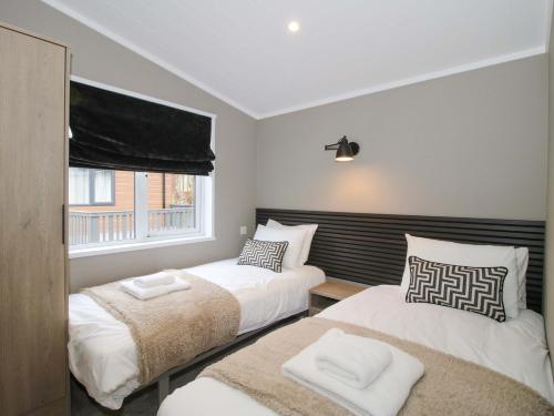 a bedroom with two beds and a window at Poppy in Leominster