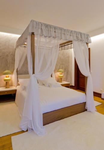 a bedroom with a white bed with a canopy at Villa Maria Caetana in Frazão