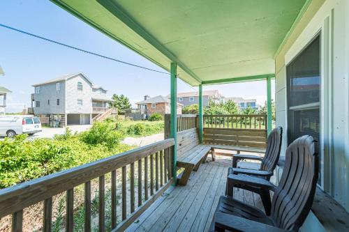 two chairs sitting on the porch of a house at Bennett's Bungalow - S Nags Head MP 17, 30 Yds to Beach, Year Round Flex Stays in Whalebone