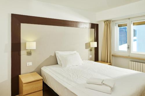 a bedroom with a large bed with two towels on it at Hotel Hermitage in Sestriere