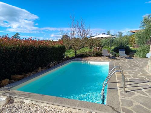 a swimming pool in a yard with an umbrella at Chalet Melograno by Interhome in Sutri