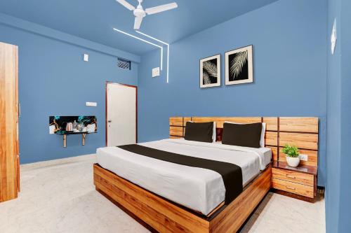 a bedroom with a large bed with a blue wall at Super Hotel O Daysinn Premium in Bhubaneshwar