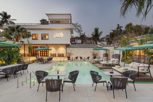 a resort with a pool and tables and chairs at Sere Resort Goa in Goa