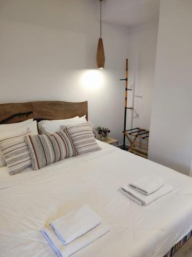 a large white bed with three towels on it at Reborn Project Acropolis in Skiathos