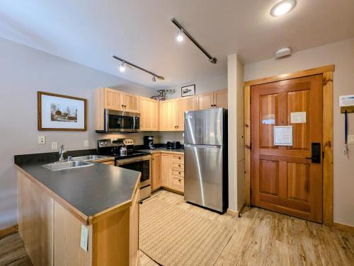 a kitchen with a stainless steel refrigerator and wooden cabinets at Buffalo Lodge 8320 by SummitCove Lodging in Keystone