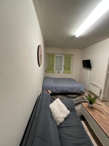 a room with a couch and a bed and a clock at Le Nid du Centre in Anzin