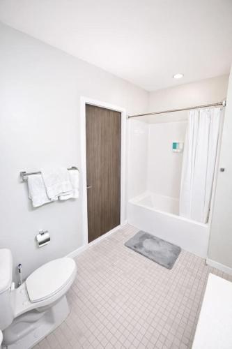 a white bathroom with a toilet and a shower at Cobalt Cove (132) in Des Moines