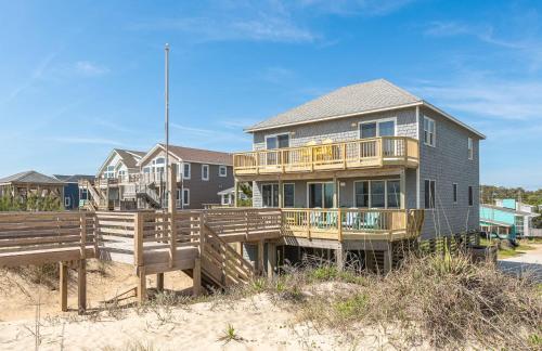 a house on the beach with a wooden deck at Pier Pleasure - S Nags Head MP 17, Oceanfront, Private Beach Access, Ocean View, Fireplace in Whalebone