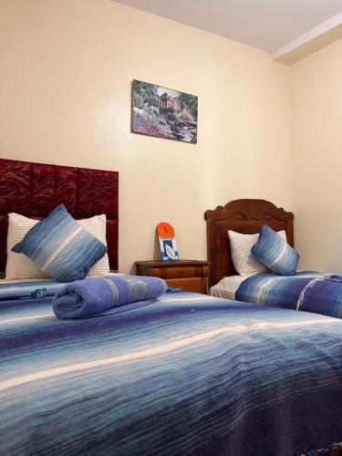 a bedroom with two beds with blue pillows at Casa laila in Chefchaouen
